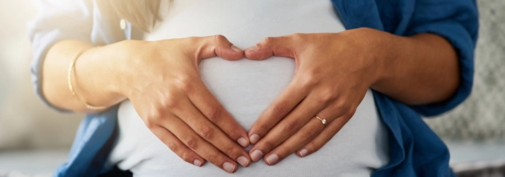 Chiropractic Merrick NY Woman Heart Over Belly Healthy Pregnancy